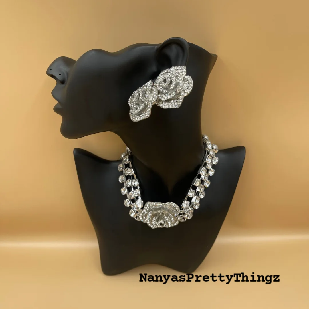Sparkling silver crystal necklace and earring set displayed on a black mannequin